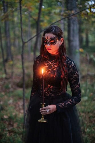 halloween-wedding-ideas-photo-shoot-with-a-bride-in-a-black-dress-and-a-mask-with-candles-in-her-hands-artemis-photography-334x500.jpg