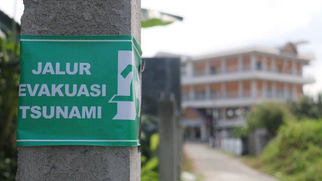 Penunjuk Arah Evakuasi Tsunami Dengan Latar Escape Building,  Desa Deah Glumpang.jpg