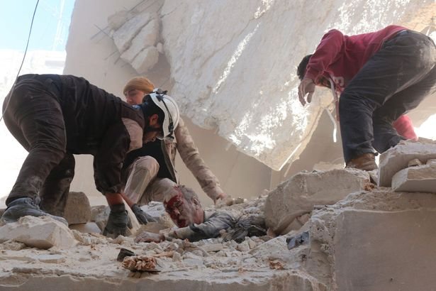 Syrian-rescue-workers-and-residents-try-to-pull-a-man-out-from-under-the-rubble.jpg