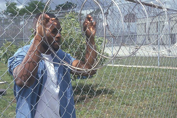 inmate-at-barbed-wire-fence-dade-county-mens-correctional-facility-picture-id144078547.jpg