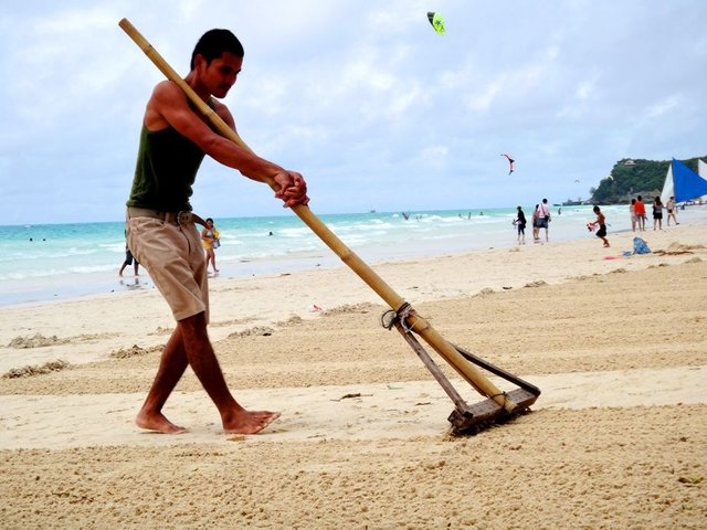 a-local-raking-the-beach-in-boracay.jpg