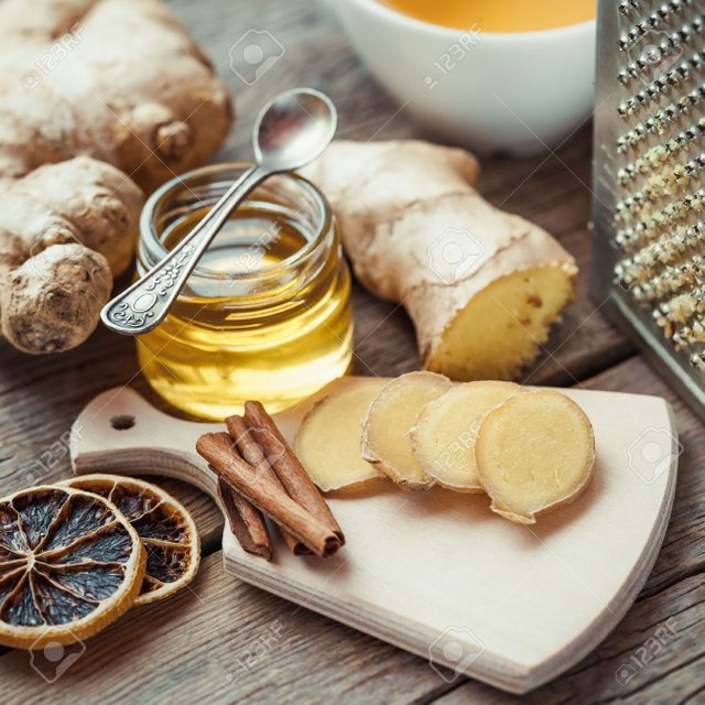 47628007-Ginger-on-cutting-board-jar-of-honey-dried-lemon-slice-cinnamon-and-grater-on-kitchen-table-Selectiv-Stock-Photo.jpg