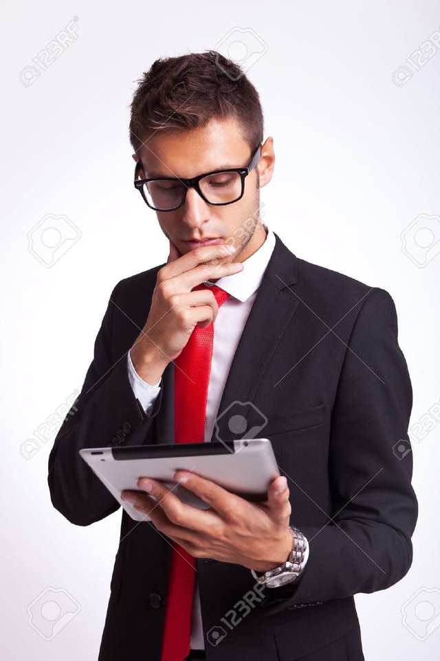 15500223-young-business-man-is-intrigued-by-the-news-he-is-reading-onhis-new-tablet-pad-Stock-Photo.jpg