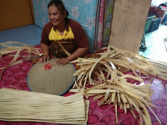 Kambai makes 'Tanggui' for own use.  She used Sago leaves to make the hat.jpg