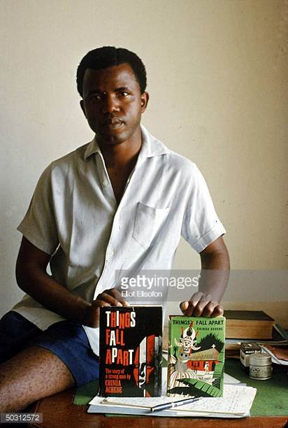 nigerian-author-chinua-achebe-holding-two-editions-of-his-book-things-picture-id50312572.jpg