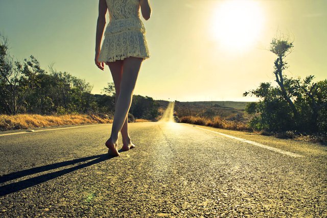 mujer-caminando-descalza-por-una-carretera.jpg