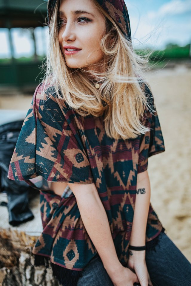 kaboompics_Beautiful blonde woman relaxing with a can of coke on a tree stump by the beach.jpg