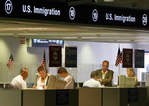 immigration-inspectors-check-passports-july-2-2002-at-miami-airport-picture-id892697.jpg