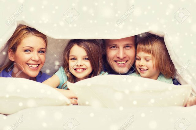 49277481-family-children-comfort-bedding-and-home-concept-happy-family-with-two-kids-under-blanket-over-snowf-Stock-Photo.jpg