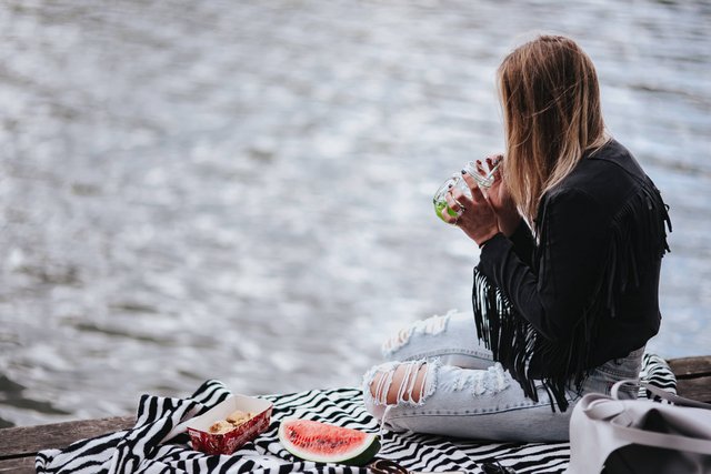 kaboompics_Blonde woman having a healthy snack at the wooden pier (2).jpg