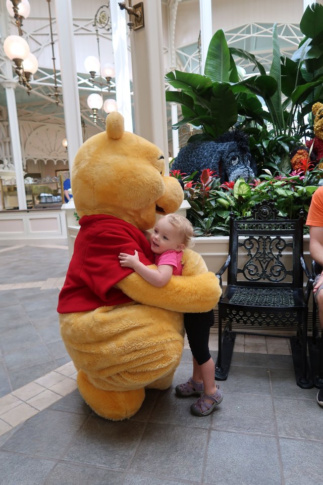 Winnie The Pooh huges little girl at Crystal Palace Magic Kingdom theme park at Walt Disney World Resort September 2017.JPG