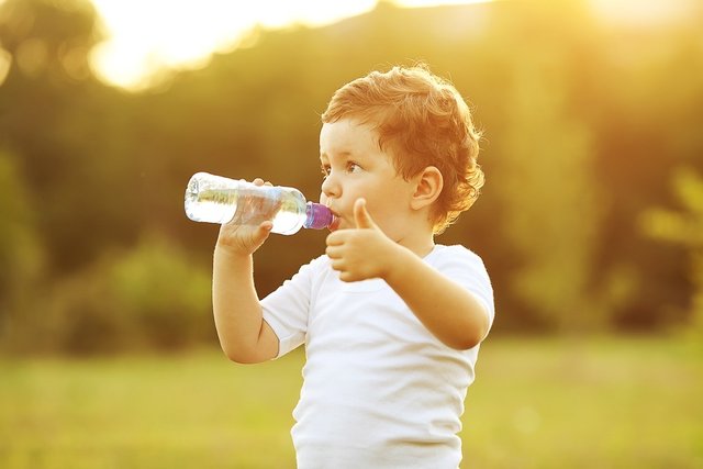 crianca-bebendo-agua-na-garrafa-e-fazendo-sinal-de-positivo-foto-selinsshutterstockcom-000000000001650D.jpg