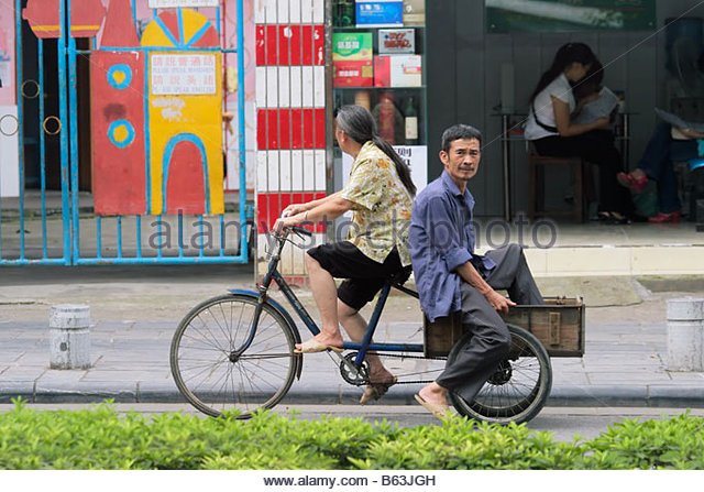 chinese-woman-and-man-riding-on-a-bicycle-in-a-street-of-guilin-china-b63jgh.jpg