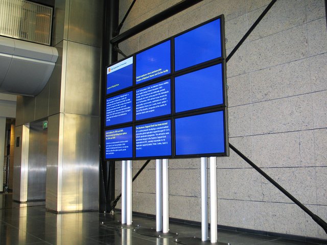 Digital Signage board showcasing a blue screen with tiny ads