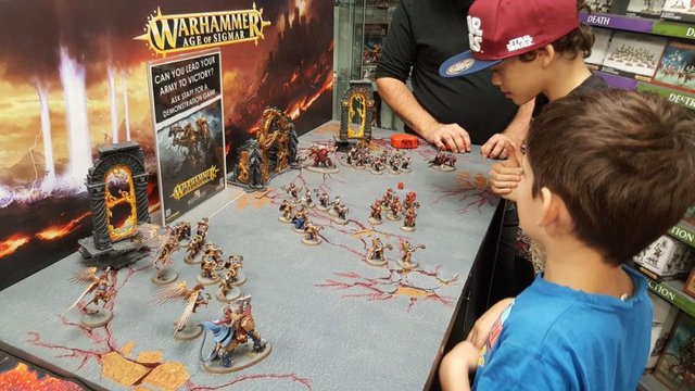 Boys being taught how to play Warhammer Age of Sigma at a Games Workshop in Perth, Western Australia