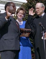 Virginia Thomas looks on as her husband, Clarence Thomas, takes the oath of office to become an associate justice of the US Supreme Court. Public domain.