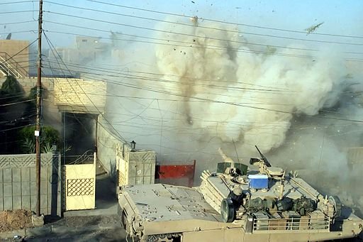 US Marine Corps tank taking part in the Rape of Fallujah (Iraq, 2004). Public Domain.