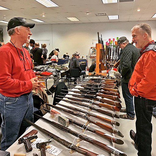 US Senator Dan Sullivan R-AK) at Eagle River Lions Club Gun Show. United States Senate -- Office of Dan Sullivan. Public Domain.
