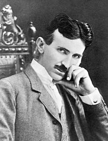 Photograph of Nikola Tesla, a slender, moustachioed man with a thin face and pointed chin.
