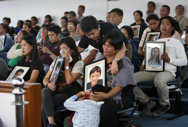 Parents of children vaccinated with Dengvaxia cry during a Senate hearing