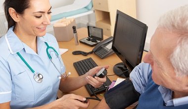 Nurse taking elderly man's blood pressure