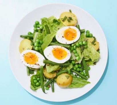 Boiled egg, pea, potato and lettuce salad on a plate