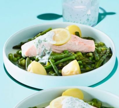 A bowl of green vegetables topped with a trout fillet