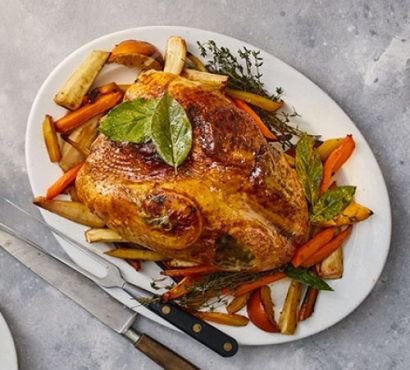 Roast turkey crown surrounded by root vegetables