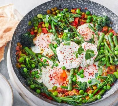 A dish with pea and broad bean shakshuka with eggs