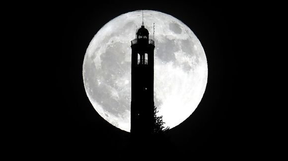 The super moon rises above the lighthouse of San Maurizio