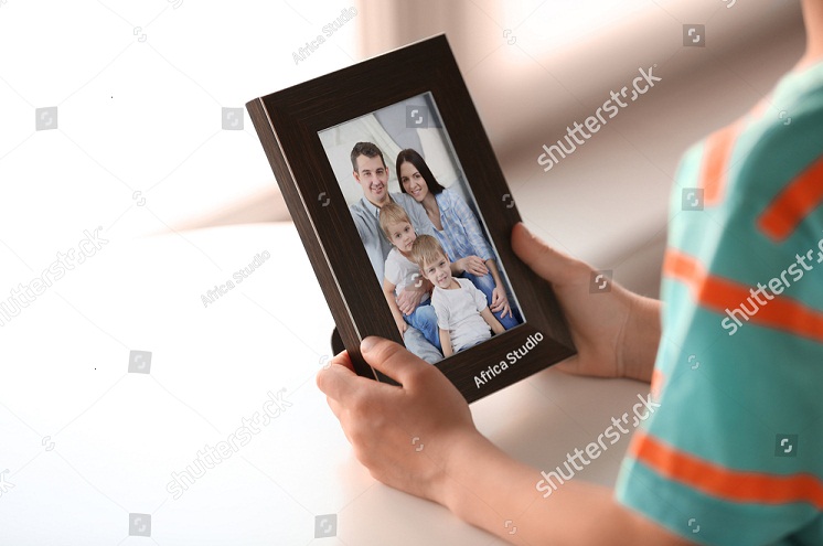 stock-photo-little-boy-holding-photo-frame-with-picture-of-family-happy-memories-concept-499594756.jpg