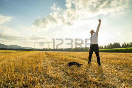 42851670-young-businessman-standing-in-the-field-and-raising-his-arm-for-success-while-throwing-his-coat-on-t(1).jpg