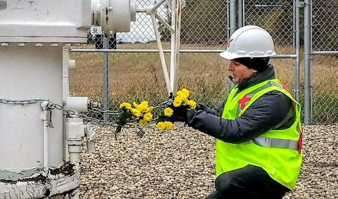 Michael-Foster-hanging-yellow-chrysnathemums-along-his-own-chain-securing-the-Keystone-Pipeline-valve-photo-provided-by-John-Foster.png