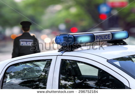 stock-photo-police-officer-emergency-service-car-driving-street-with-siren-light-blinking-296752184.jpg