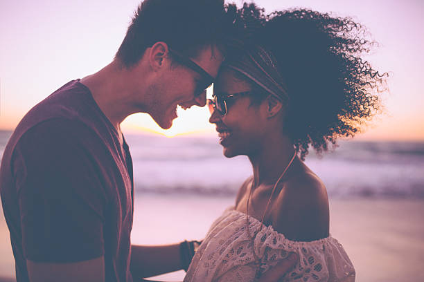 mixed-race-couple-sharing-a-romantic-moment-at-sunset-picture-id471881668.jpeg