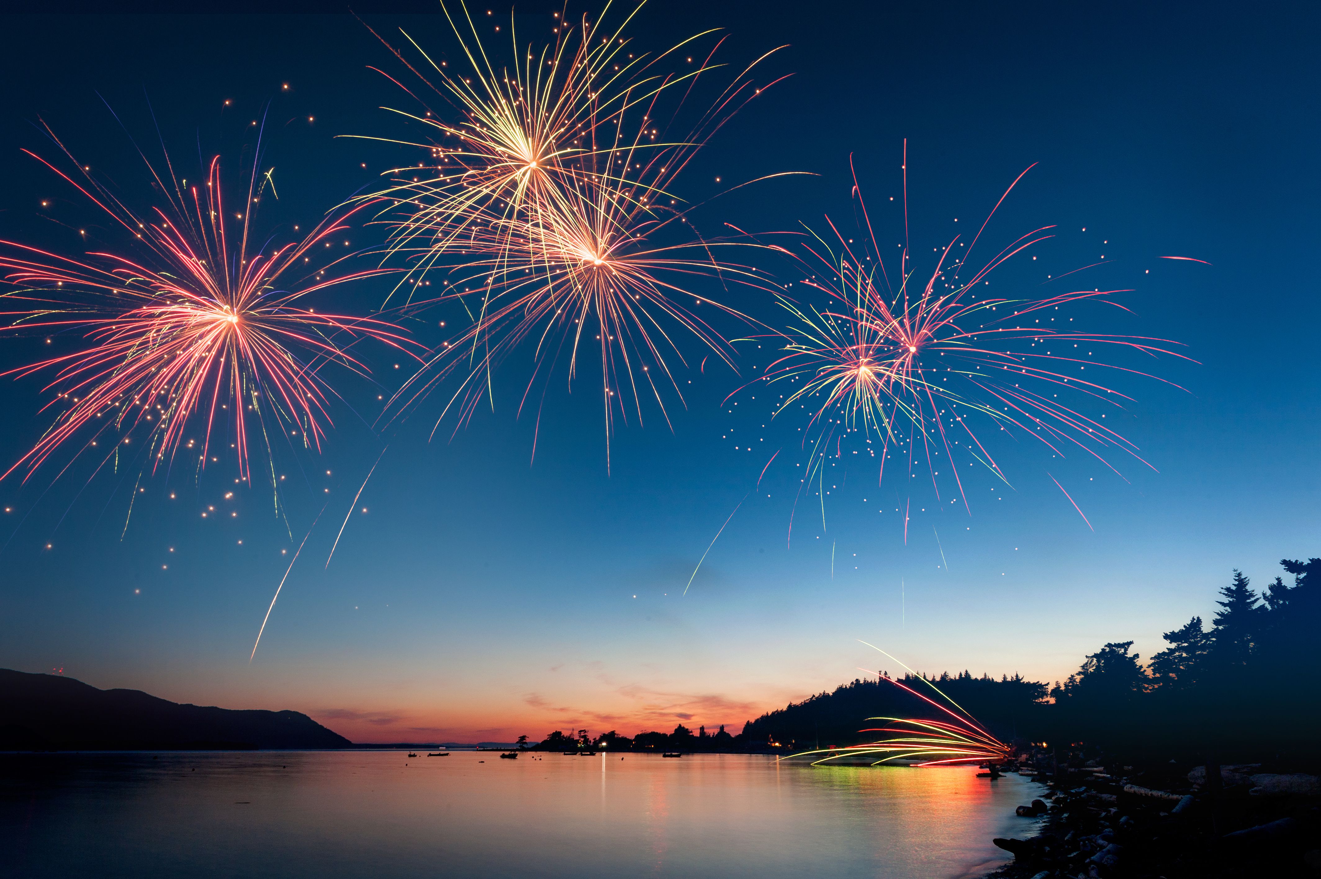 low-angle-view-of-firework-display-over-river-during-sunset-604213021-57752e7b3df78cb62c11aba4.jpg