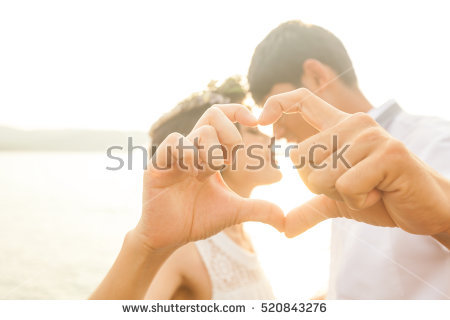 stock-photo-couple-in-love-gesturing-heart-with-fingers-against-sunrise-520843276.jpg