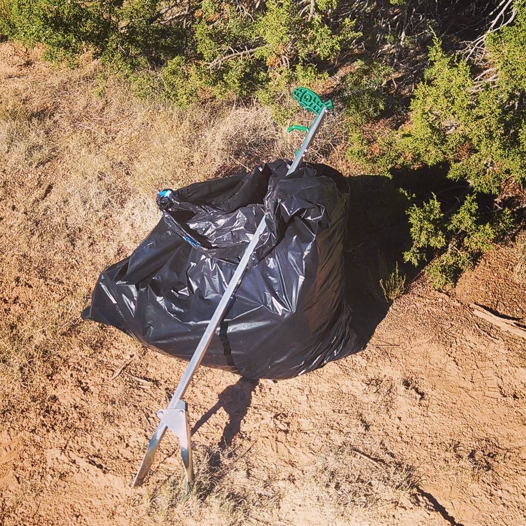 plastic bag of trash with trasher picker-upper gadget