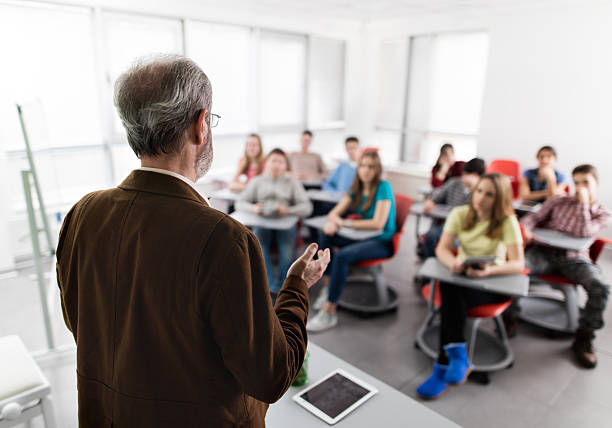 rear-view-of-a-male-teacher-giving-a-lecture-picture-id519588486.jpeg