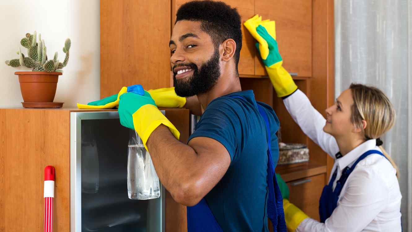 hombre-con-barba-y-camiseta-azul-limpiando-un-mueble-junto-a-una-mujer-rubia.jpg