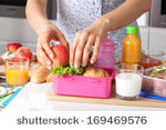 stock-photo-young-woman-making-school-lunch-in-the-morning-169469576.jpg