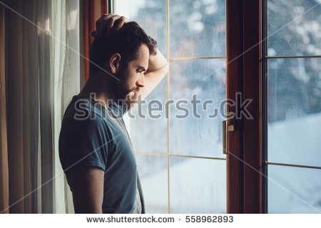 stock-photo-young-sad-mad-sitting-by-the-window-in-regret-558962893.jpg