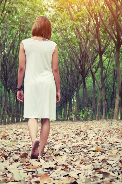 rear-view-of-girl-walking-on-the-ground-covered-with-leaves_1150-334.jpg