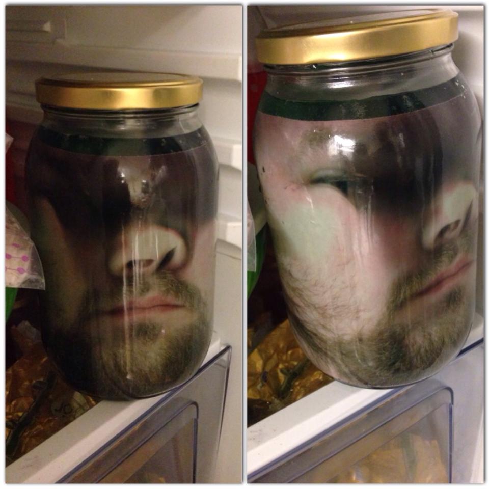 Man prints a photo of his face on photo paper and places it in a jar with green water to scare his wife on Halloween.jpg