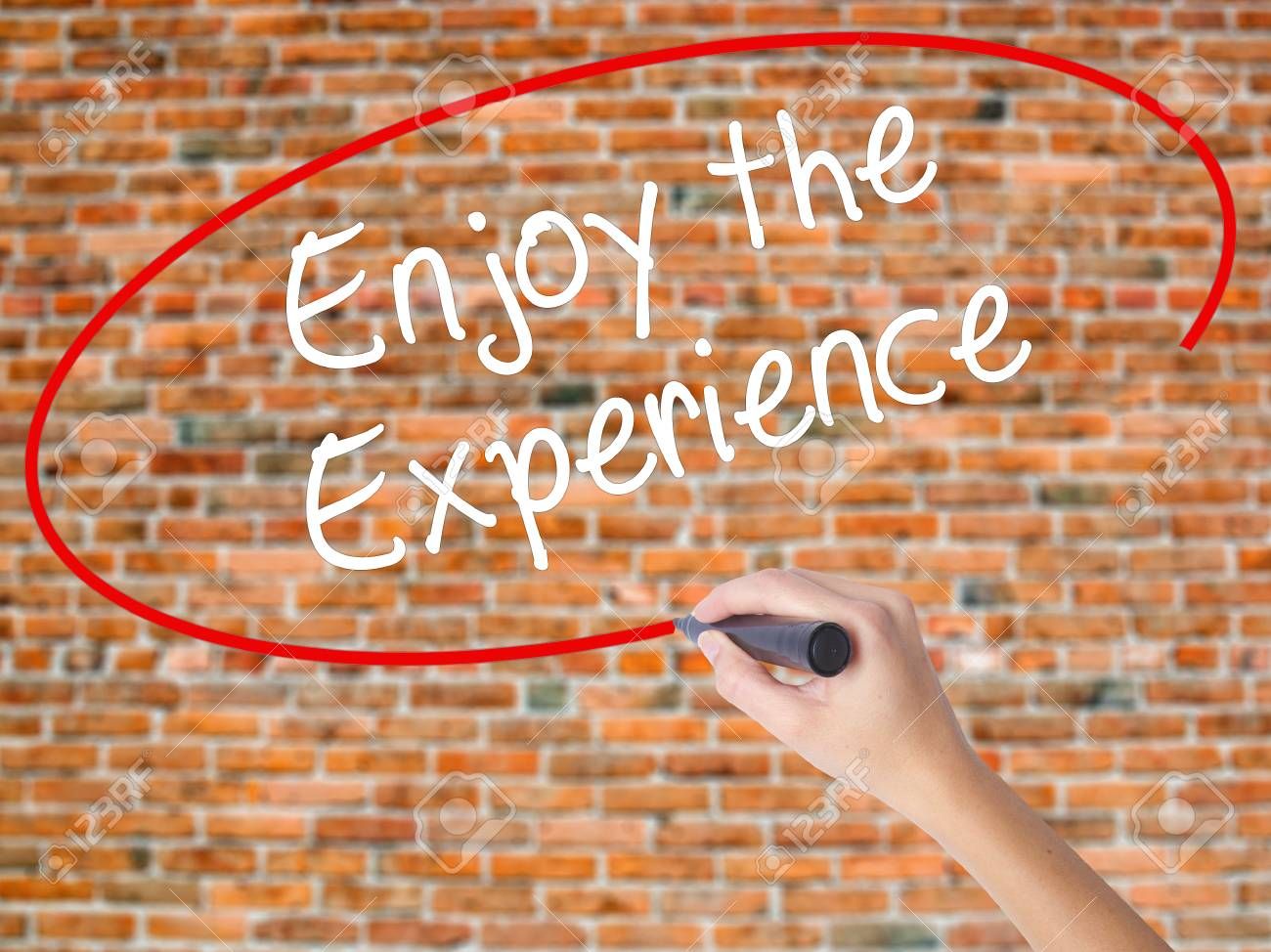 71596305-woman-hand-writing-enjoy-the-experience-with-black-marker-on-visual-screen-isolated-on-bricks-busine.jpg