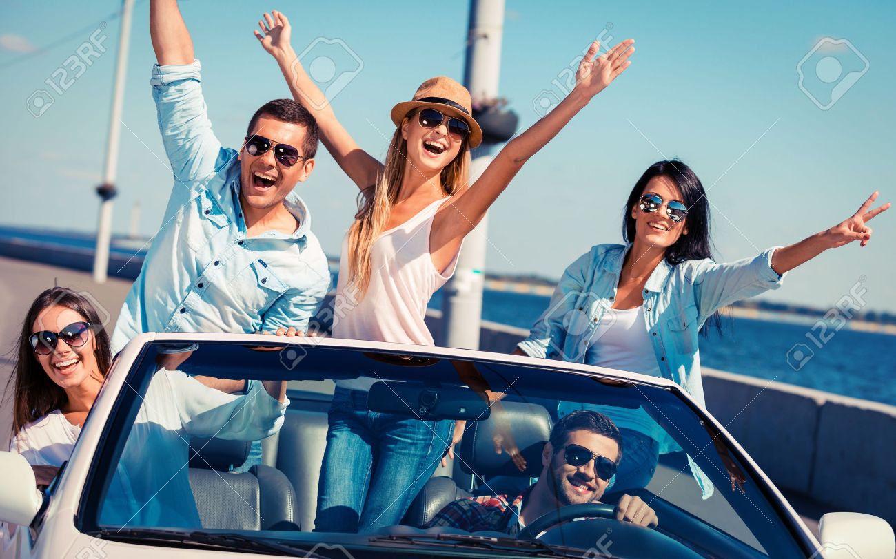 32368228-friends-in-convertible-group-of-young-happy-people-enjoying-road-trip-in-their-white-convertible-and.jpg