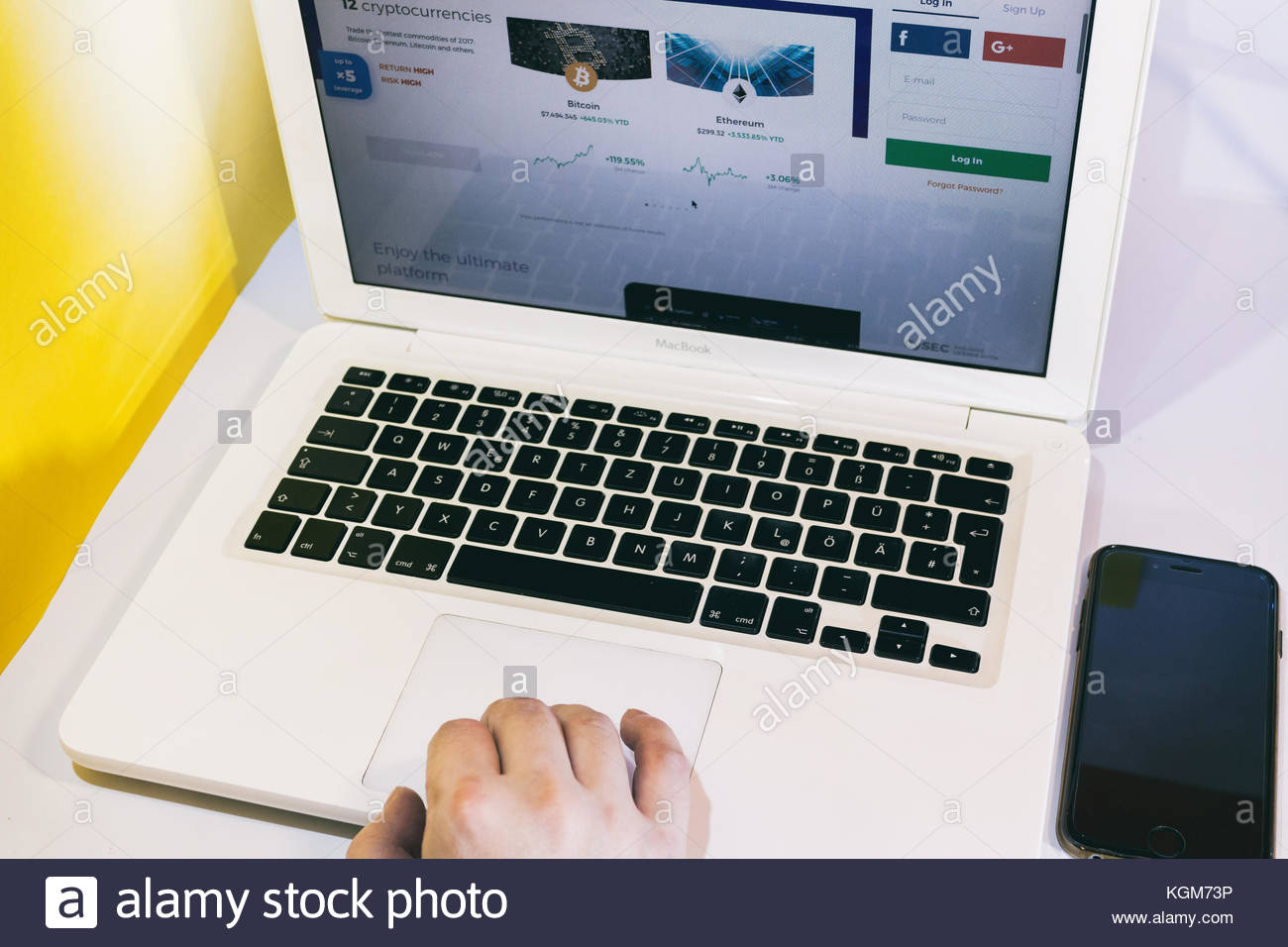 young-men-using-a-macbook-browsing-the-internet-for-crypto-currency-KGM73P.jpg