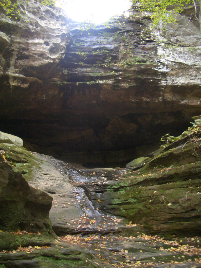 The sun peeking over the ledge of a sandstone cliff