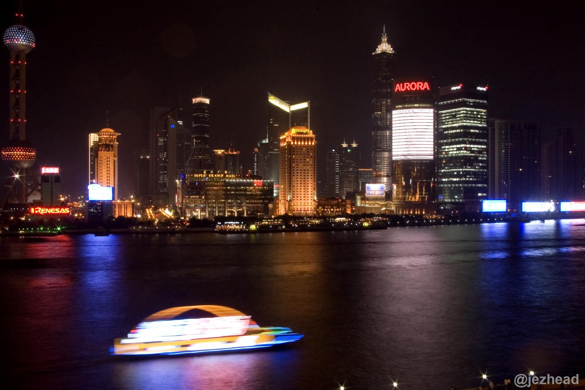 Exposure of Shanghai at Night - Blurred Boat on River Traveling Past Illuminated Skyline of Shanghai.jpg