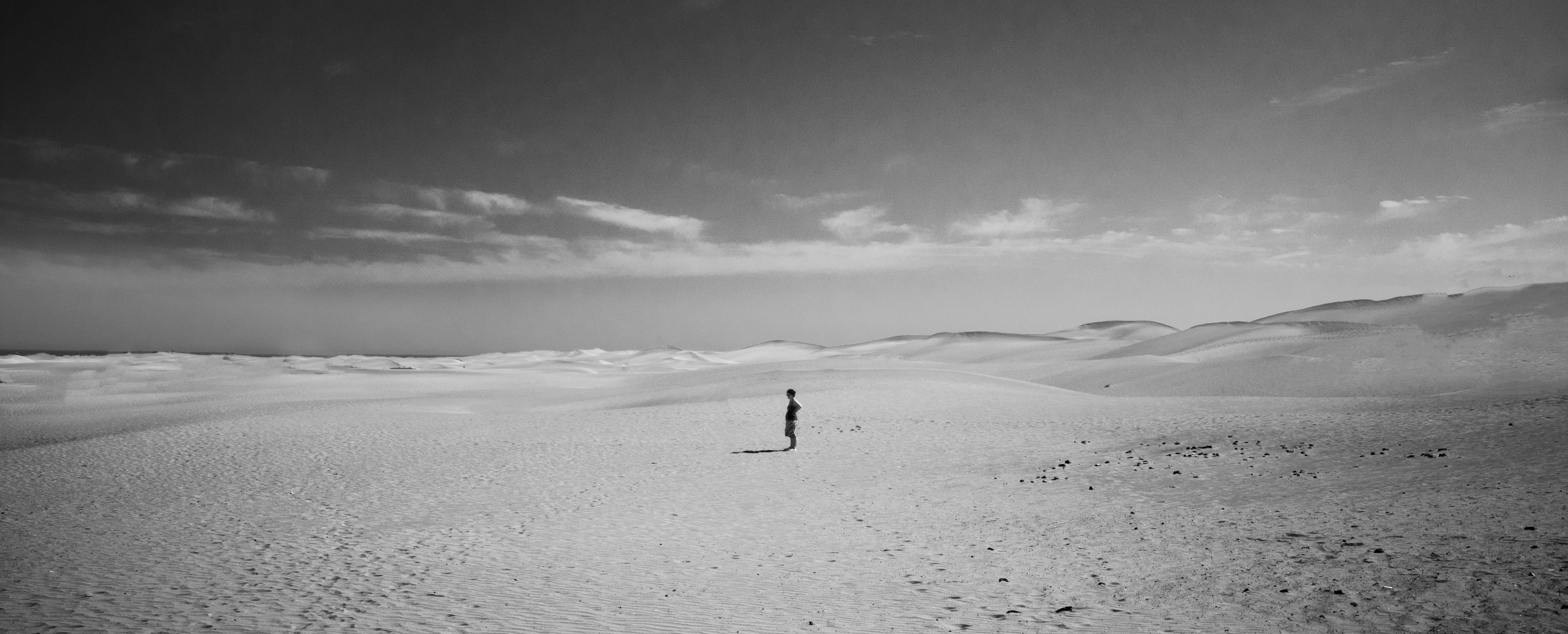 Example of negative space illustrated through a landscape image of a desert, with the focus of a man's silhouette in the center
